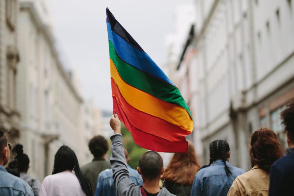 people marching in pride parade showing how to support lgbtq