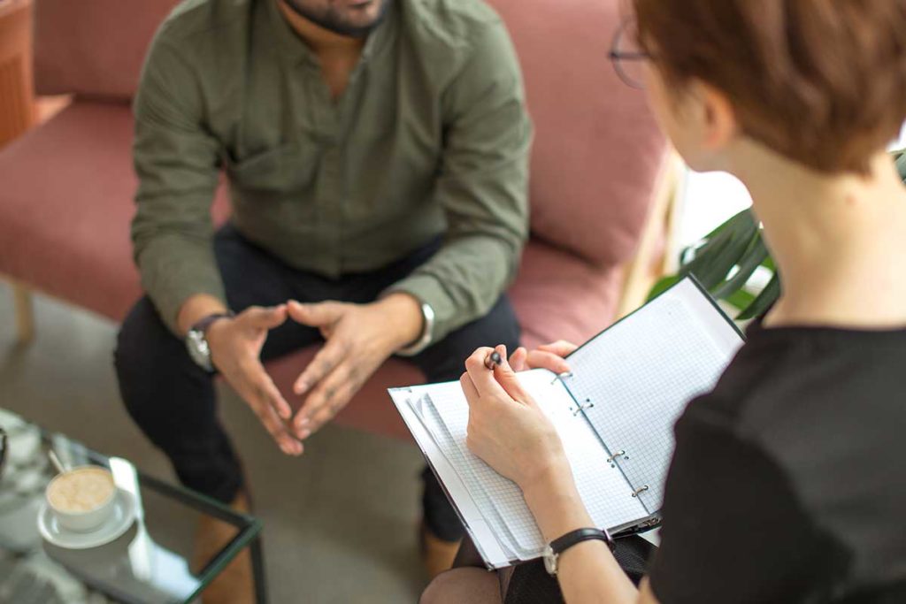 man sitting on coach realizing what is recovery coaching and participating in recovery coaching