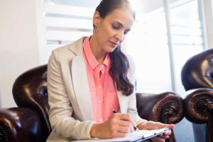 a woman writing on a notepad and learning what is treatment planning