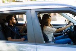 a man in recovery sits in the backseat of car and is utilizing sober transport services