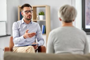 a male therapist talks with an adult woman patient about financial coaching