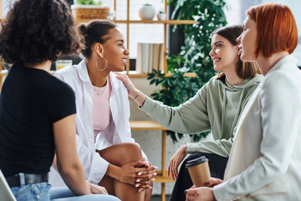 four women sit together in a circle and discuss how to find a sober living home in austin tx