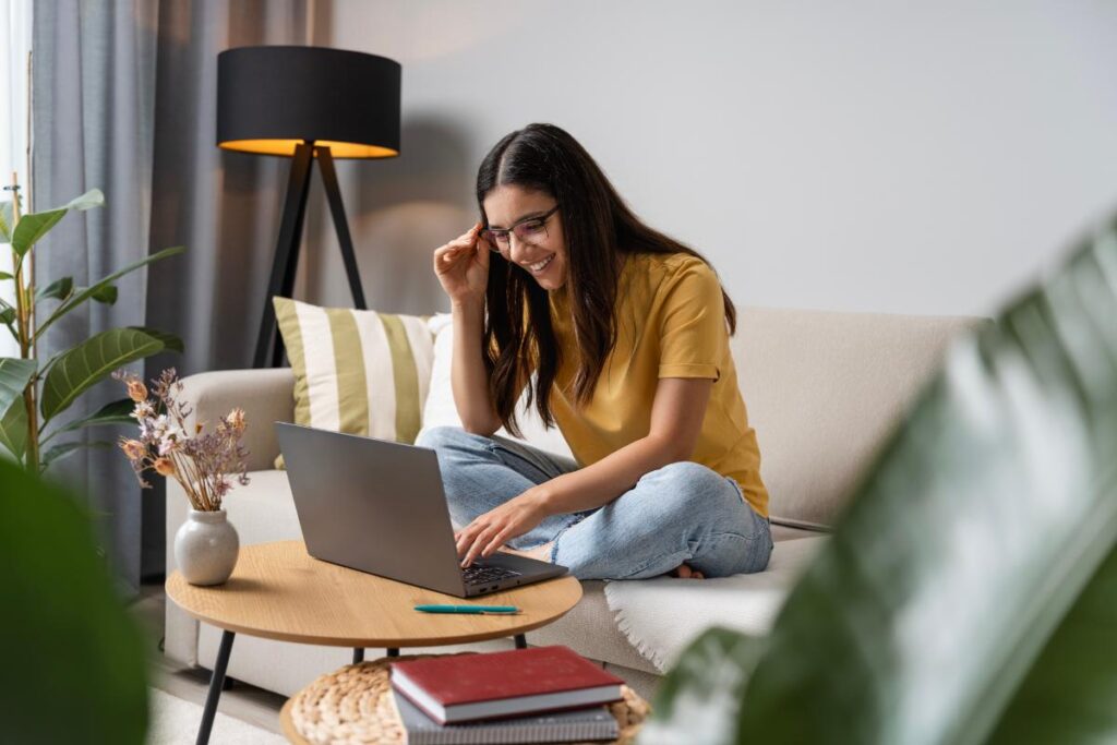 a woman sits on a couch while on her laptop searching the meaning of aa chips in order and what their colors mean