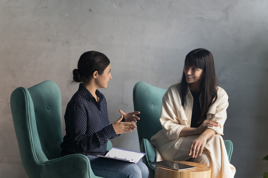 a woman checks in with her counselor in sober living
