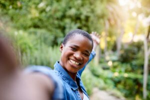 a smiling woman thrives in sober living after rehab
